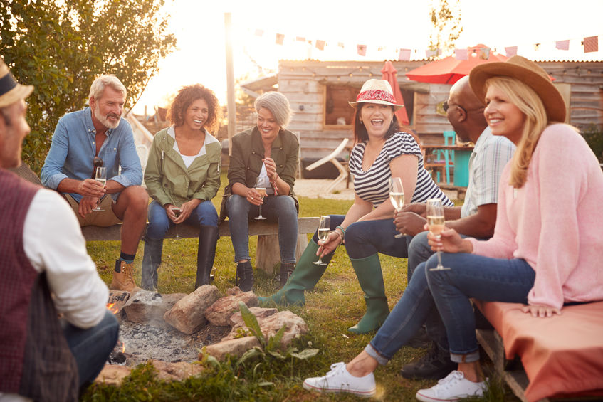 Company employees enjoying a corporate retreat around a campfire