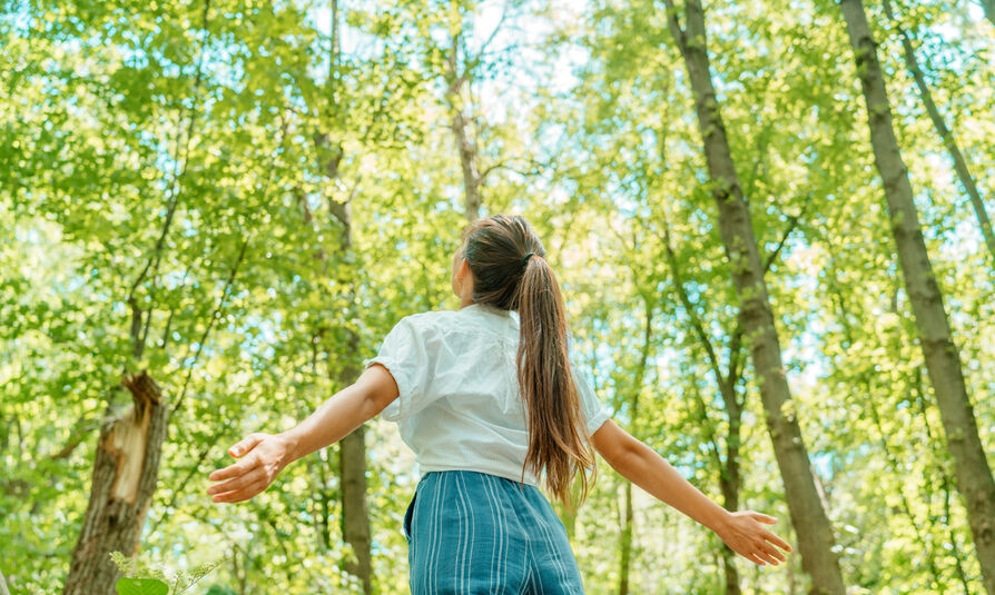 Free woman breathing clean air in nature forest.